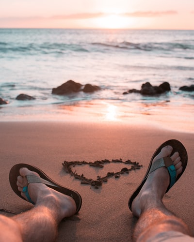 Sitting in the sand near the water
